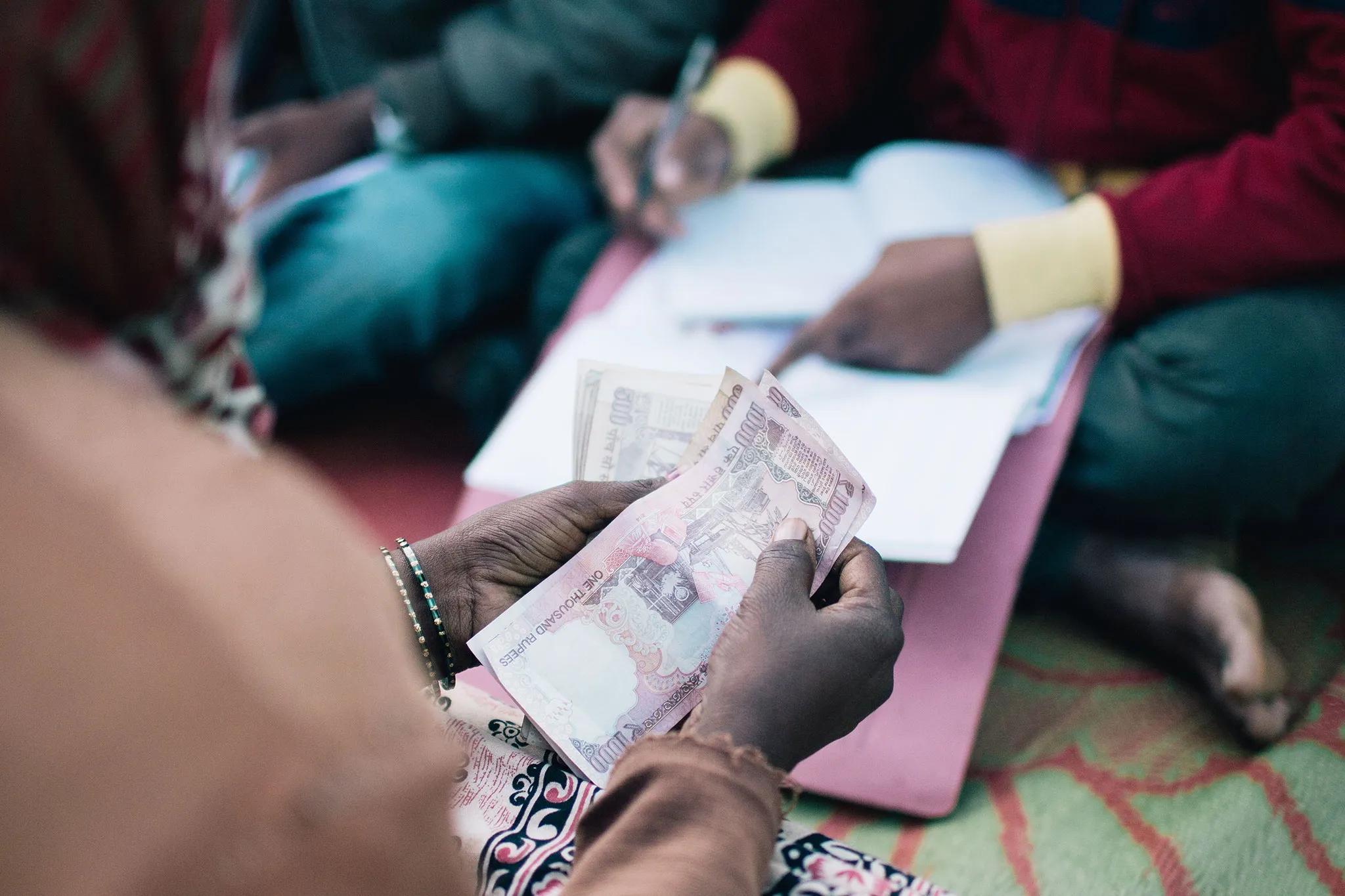 Woman making a payment on her microfinance loan for a water or sanitation solution.