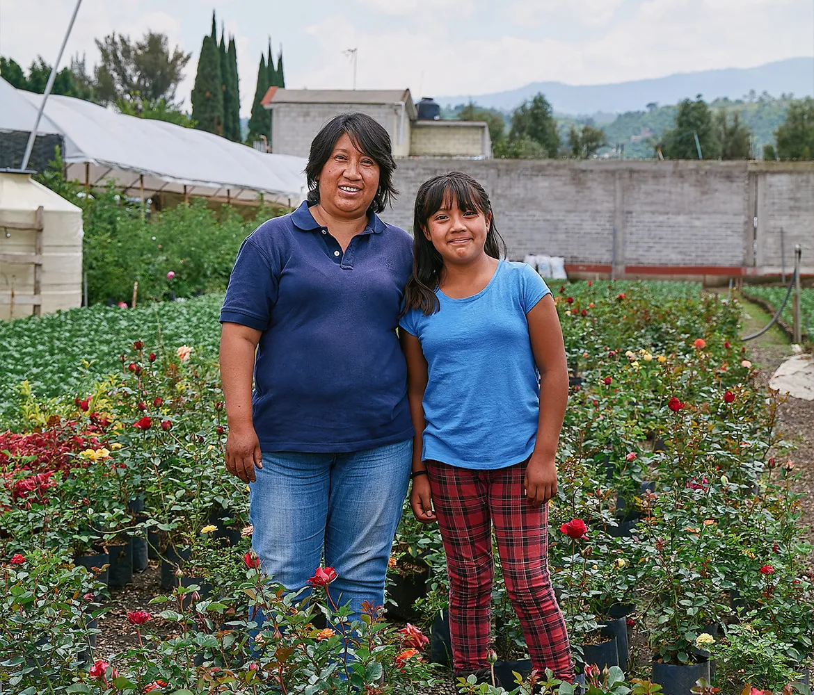 Mother and daughter standing in their flower garden in Mexico.