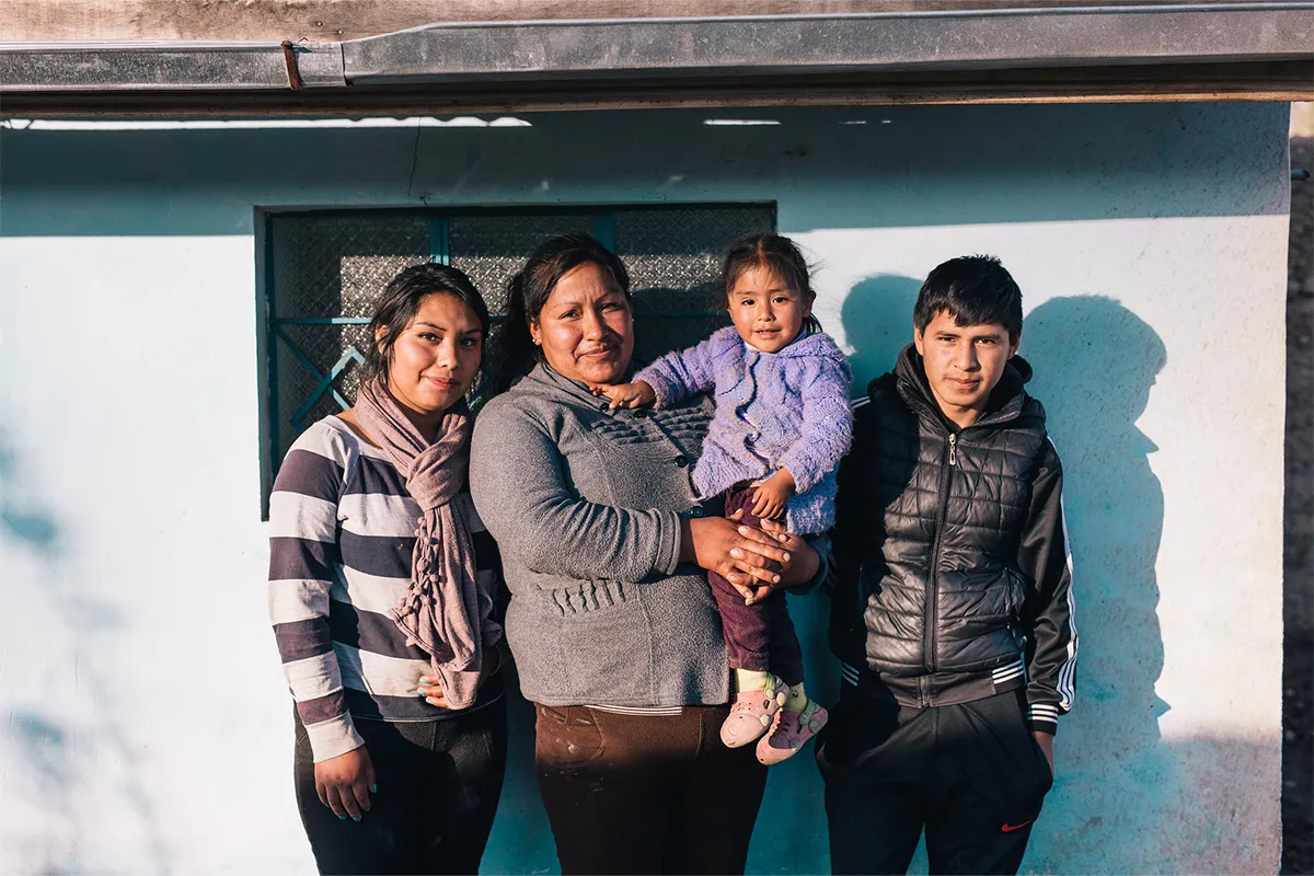 A family stands in front of their home in Peru.